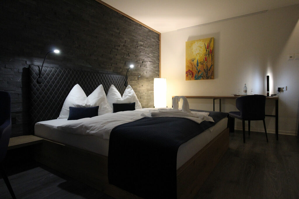Blick auf das Doppelbett der Juniorensuite im Privat & Boutique Hotel Lenz in Fünfseen